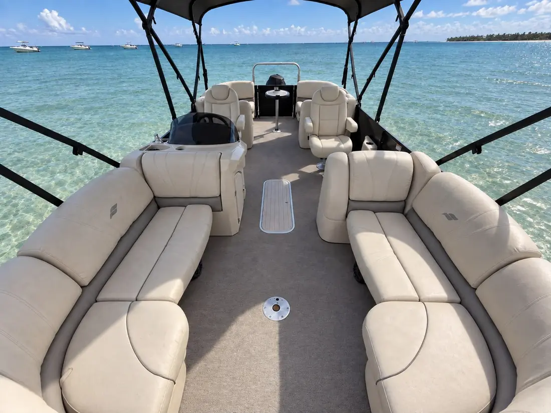 Wraparound lounge seating under the Bimini top, looking forward to the helm